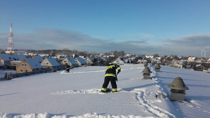 Strażacy z łopatami na lodowisku